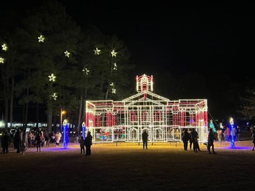 A brightly lit building decorated with colorful lights, surrounded by people enjoying a festive night.