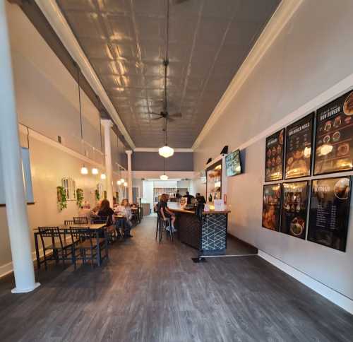 Interior of a restaurant featuring a bar area, seating for customers, and menu boards on the wall.