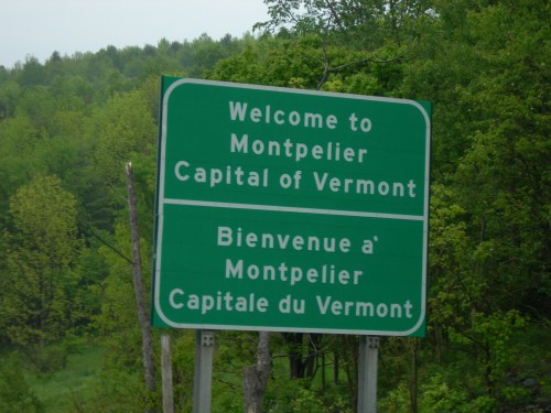 Green welcome sign for Montpelier, Vermont, displaying both English and French text.