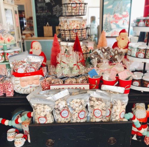 A festive display of holiday treats, including popcorn, cookies, and decorative items, with Santa-themed decorations.