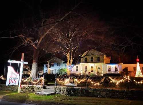 A charming inn decorated with festive lights and holiday decorations, set against a dark night sky.