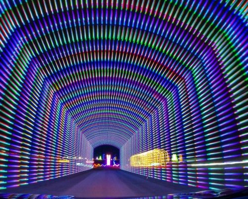 A colorful, illuminated tunnel with vibrant, swirling lights creating a dynamic visual effect.