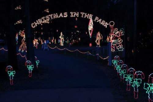 A festive entrance archway reading "Christmas in the Park," adorned with colorful holiday lights and decorations.
