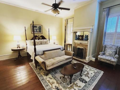 Cozy bedroom with a four-poster bed, vintage furniture, a fireplace, and soft lighting.