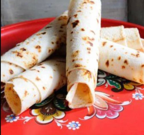 A colorful plate with rolled flatbreads, showcasing a golden-brown texture and intricate floral design.