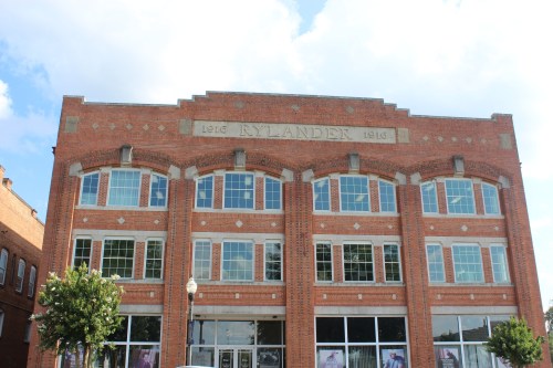 Historic brick building with large windows, featuring the name "Rylander" and the year "1916" prominently displayed.