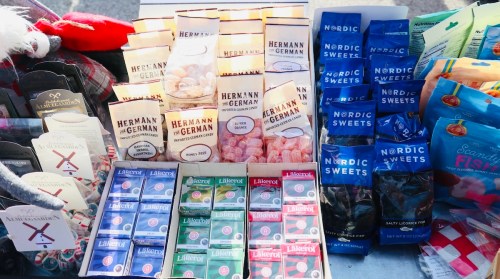 A display of various candies, including Hermann German sweets and Nordic Sweets, arranged in colorful packaging.