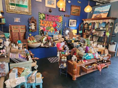 A vibrant shop filled with eclectic decor, handmade crafts, and colorful artwork on the walls. Cozy and inviting atmosphere.