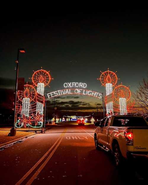 Entrance to the Oxford Festival of Lights, adorned with colorful holiday lights against a darkening sky.