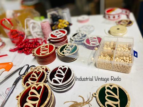 Craft supplies scattered on a table, including colorful ornaments, beads, and ribbons for a vintage project.