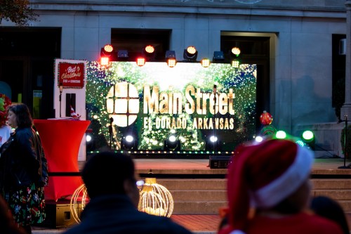 A festive event stage with colorful lights and a large "Main Street" sign in El Dorado, Arkansas.