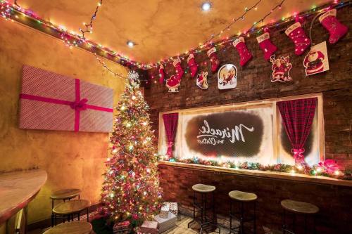 Cozy holiday scene with a decorated Christmas tree, colorful lights, stockings, and gifts in a warm, inviting space.