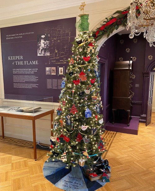 A decorated Christmas tree with lights and ornaments, set in a room with historical displays and festive decor.