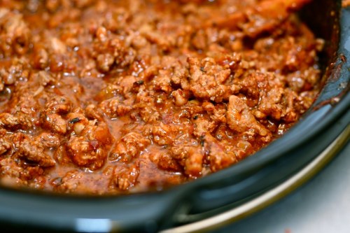 A close-up of a pot filled with rich, cooked ground meat in a savory sauce.