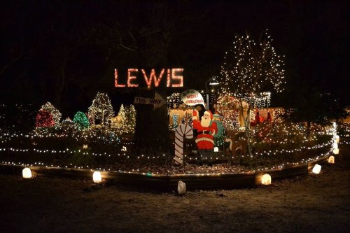 A festive display of Christmas lights, featuring Santa, candy canes, and colorful trees in a nighttime setting.