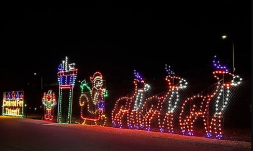 Colorful Christmas lights display featuring Santa, reindeer, and festive decorations against a dark night sky.