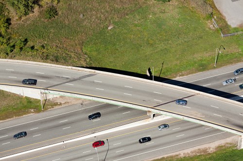 Aerial view of a highway interchange with multiple lanes and vehicles traveling in different directions.