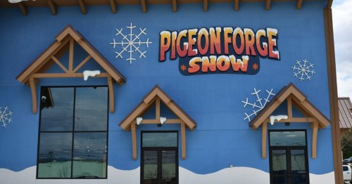 Colorful building exterior with "Pigeon Forge Snow" sign and snowflake decorations on a blue background.