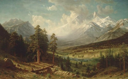 A serene mountain landscape with towering peaks, lush forests, and a tranquil valley under a cloudy sky.