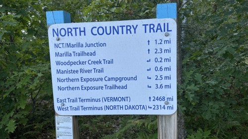 Signpost for the North Country Trail with distances to various trailheads and terminus points in Vermont and North Dakota.