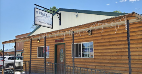 Exterior of 9 Peaks Restaurant & Lounge, featuring a wooden facade and a welcoming entrance with a sign above.