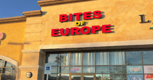 Sign for "Bites of Europe" on a restaurant exterior, featuring bright red letters against a tan background.