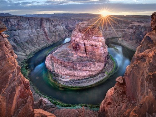 A stunning view of Horseshoe Bend at sunrise, showcasing the winding river and dramatic rock formations.