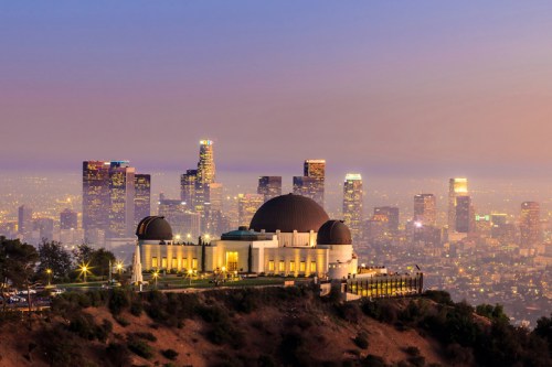 Griffith Observatory at dusk with the Los Angeles skyline illuminated in the background.