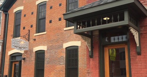 Exterior of the Drake House, featuring brick walls, large windows, and a decorative entrance awning.