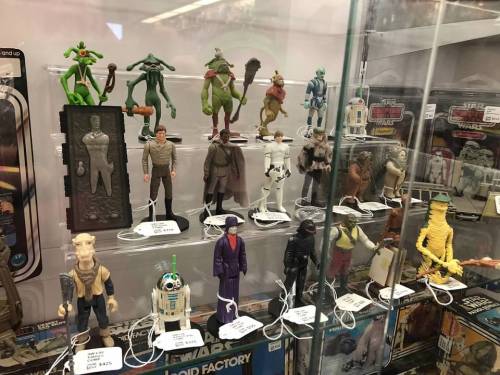 A display case filled with various action figures, including Star Wars characters and other collectibles.