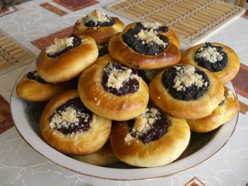 A plate of sweet pastries filled with poppy seeds and jam, topped with crumbly sugar.