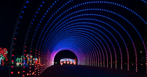 A colorful light tunnel with blue and purple lights, featuring a "Peace on Earth" sign at the end.