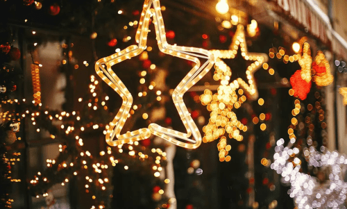 A festive display featuring glowing star-shaped lights and colorful bokeh decorations for the holiday season.