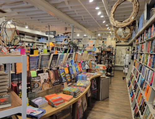 A cozy bookstore interior filled with colorful books, displays, and warm lighting, inviting readers to explore.