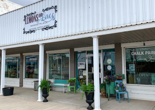 Exterior of a shop named "Lemons and Lace Marketplace," featuring antiques and gifts, with a welcoming entrance.