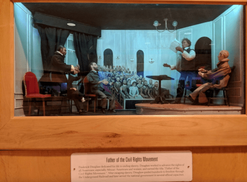 A diorama depicting Frederick Douglass speaking to a crowd about civil rights, with figures and a detailed background.