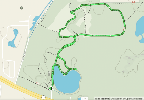 Map showing a winding trail route around a pond, with marked distances and paths in a park setting.