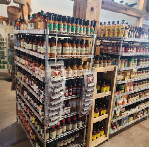 Shelves filled with various bottles of sauces and condiments in a store, showcasing a wide selection.