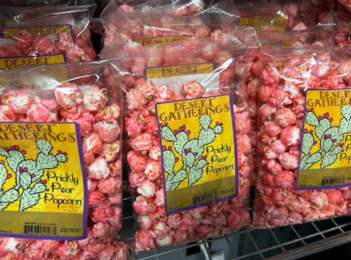 Bags of pink prickly pear popcorn on display, labeled "Desert Gatherings."