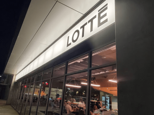 Exterior of a restaurant named "LOTTE" at night, featuring large windows and modern architecture.
