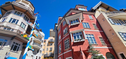 Colorful buildings under a clear blue sky, showcasing unique architectural styles and decorative elements.