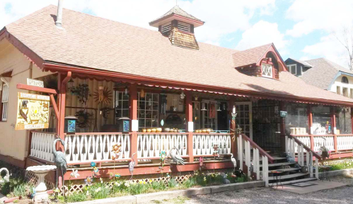 A charming, rustic storefront with a porch, colorful decorations, and a welcoming atmosphere.