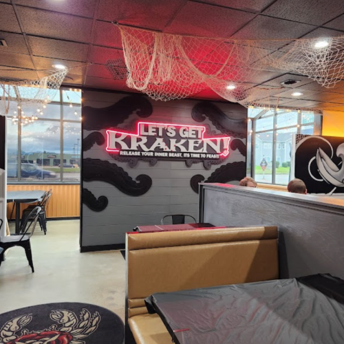 Interior of a restaurant featuring a "Let's Get Kraken!" mural, with nautical decor and seating areas.