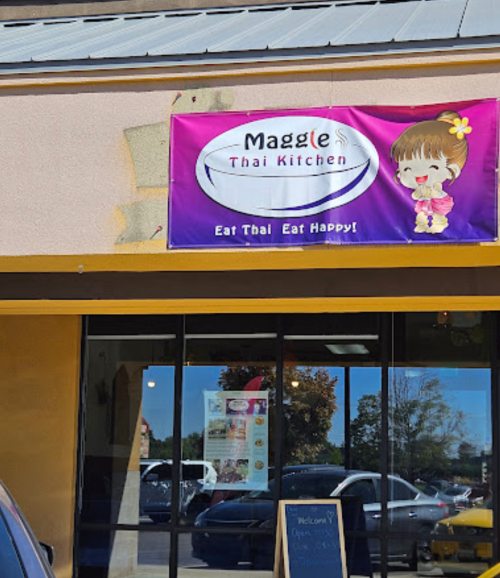 Sign for "Maggie Thai Kitchen" with a cartoon character, promoting Thai food with the slogan "Eat Thai Eat Happy!"