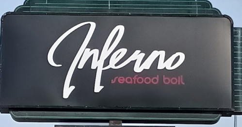 Sign for "Inferno Seafood Boil" with a stylish font on a black background.