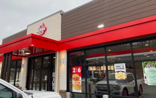 Exterior of an Arby's restaurant featuring a red awning and promotional signs for menu items.