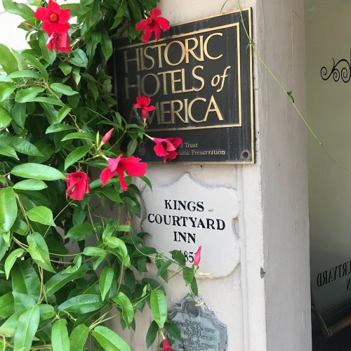 Sign for "Historic Hotels of America" with flowers and a plaque for "Kings Courtyard Inn, 1855."