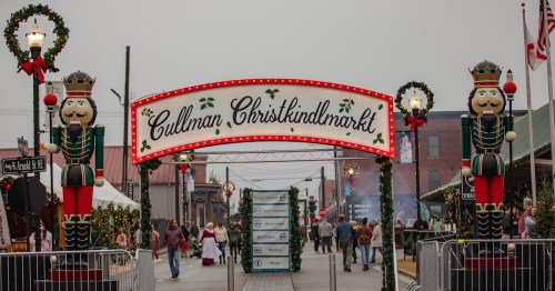 Entrance to Cullman Christkindlmarkt, featuring festive decorations and nutcracker figures on either side.