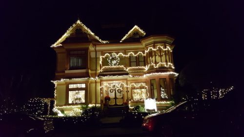 A beautifully decorated house at night, adorned with bright Christmas lights and festive decorations.