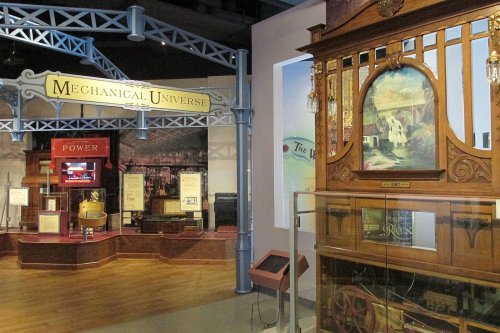 Exhibit showcasing vintage machinery and displays in a museum setting, featuring a sign for "Mechanical Universe."